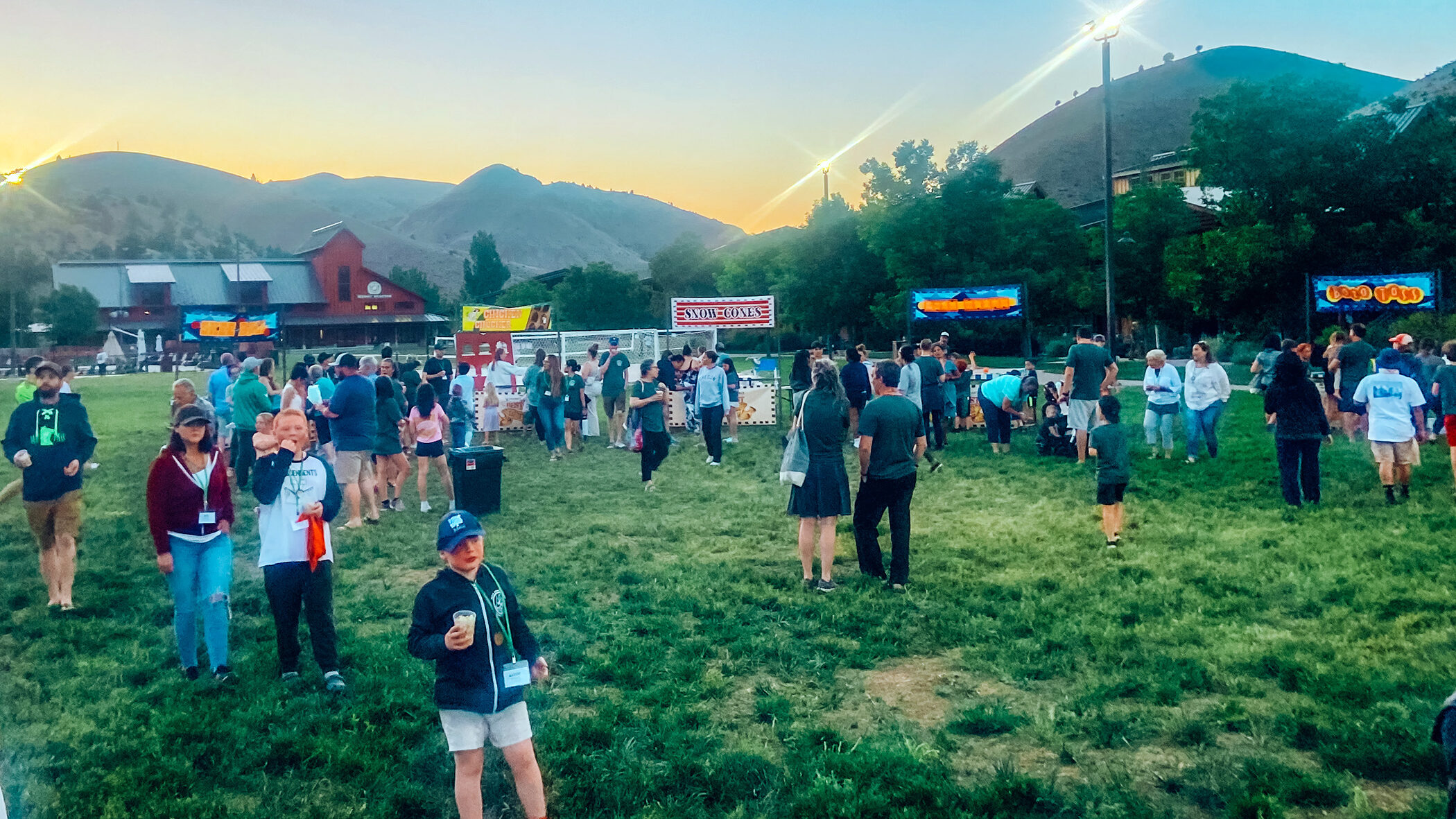 A crowd of people in a grass field at flok Family Camp West in 2023.
